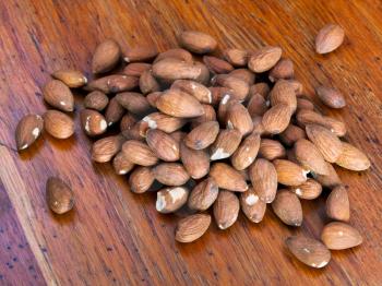 seeds of sweet almonds on wooden table