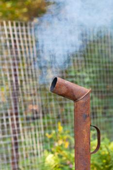 smoke from rusty pipe outdoors