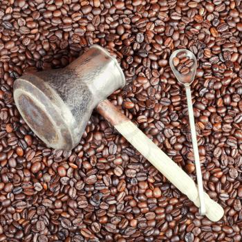 vintage coffee pot with spoon and many roasted coffee beans background