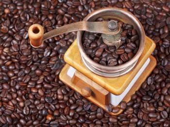 top view of retro manual coffee grinder on many roasted coffee beans