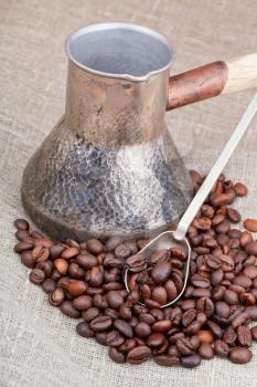 roasted coffee beans and copper coffee pot close up on bagging