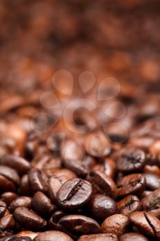 red roasted coffee beans background with focus foreground