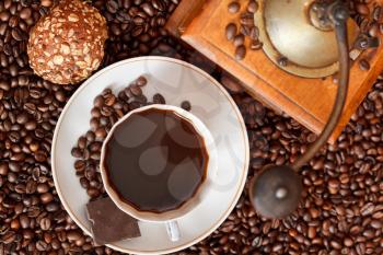 top view cup of coffee and roasted coffee beans with retro wood manual mill with biscuit