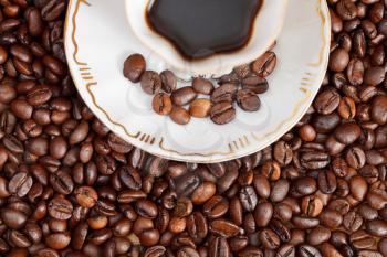 above view small cup of coffee and roasted coffee beans close up