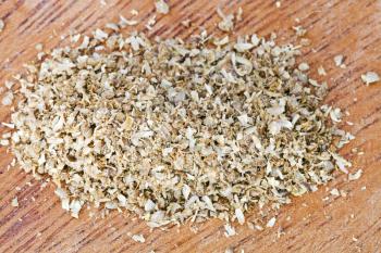 freshly ground dried coriander seeds on wooden board