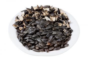 sunflower seeds and husks on plate isolated on white background