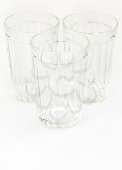 three empty faceted glasses on white background
