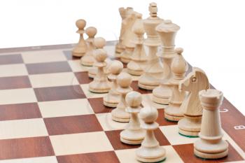 set of white chess pieces placed on chessboard close up