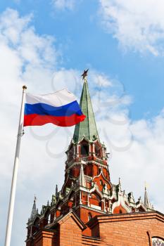 Russian state flag fluttering in wind with Kremlin Trinity tower on background