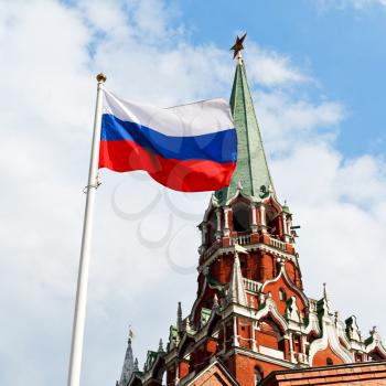 Russian state flag flying in wind with Kremlin Trinity tower on background