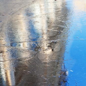 reflection of urban building in frozen puddle in morning