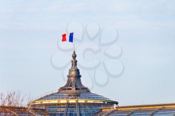 french flag on Great Palace in Paris in evening