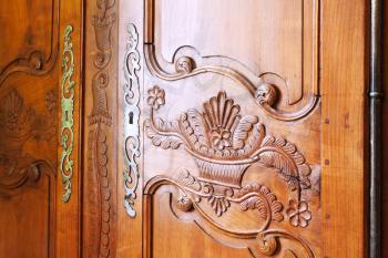 carved wooden door of antique wardrobe