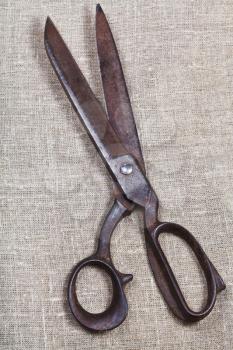 old tailor scissors on textile background