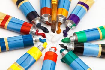 round paintbrush and set of multicolored tubes with squeezed watercolors