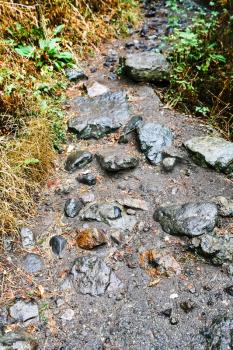 wet stones at mountain path in Geghard monastery in rain, in Armenia