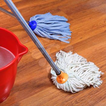 mopping of wood floors by two mops and red bucket