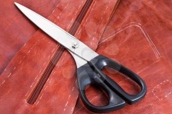 tailor shears and pattern on cutting brown leather
