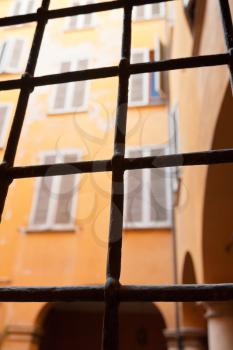 view through window iron bars on italian urban house patio