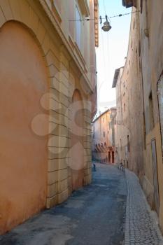 narrow street in medieval downtown of Bologna in morning, Italy