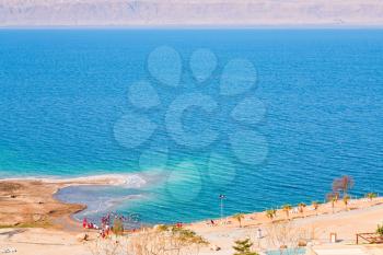 panorama with people on sand beach of Dead Sea, Jordan