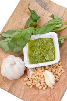 italian pesto sauce with ingredient on wooden board isolated on white background