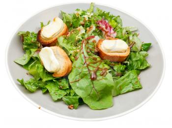 green salad with goat cheese on plate isolated on white background