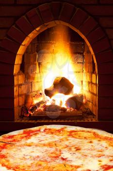 italian pizza margherita and open fire in wood burning oven