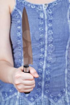 woman holding large kitchen knife in front of her