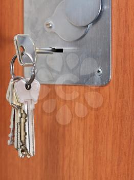bunch of home keys in keyhole of wooden door