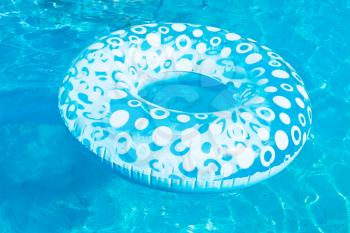 inflatable swimming circle in blue open-air pool in summer day