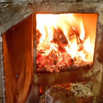 burning wood in furnace with open door close up