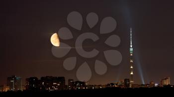 half of full moon over TV tower and city in warm summer night, Moscow