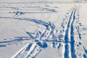 fresh tracks in snowy field in cold winter day