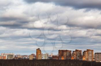 urban houses under grey blue clouds in winter evening