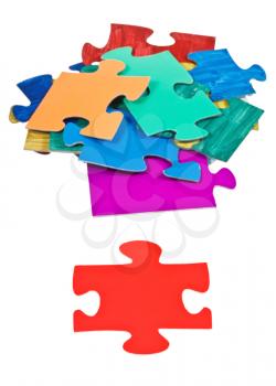 one red puzzle piece near pile of jigsaw puzzles isolated on white background