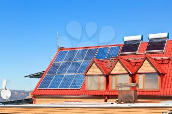 modern energy-saving technology - Solar Batteries and heaters on house roof