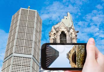 travel concept - tourist taking photo of gedachtniskirche church on mobile gadget in Berlin, Germany