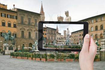 travel concept - tourist taking photo of Piazza della Signoria and Fountain of Neptune in Florence on mobile gadget, Italy