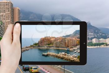 travel concept - tourist taking photo of Monaco city on mobile gadget