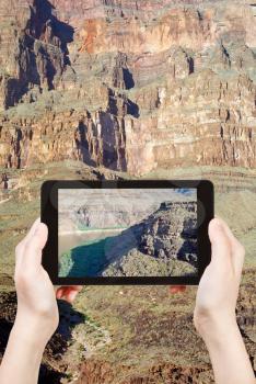 travel concept - tourist shooting photo of Colorado River in Grand Canyon on mobile gadget, Nevada, USA