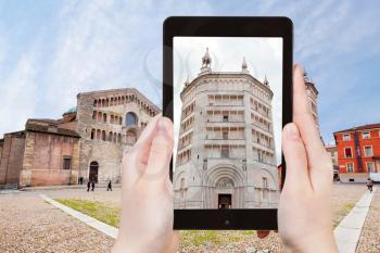 travel concept - tourist taking photo of Baptistery on Piazza del Duomo, Parma, Italy on mobile gadget