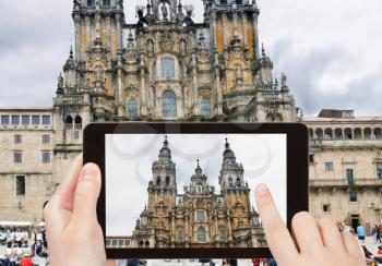 travel concept - tourist taking photo of The Cathedral of Santiago de Compostela on mobile gadget, Spain