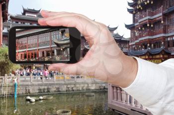 travel concept - tourist taking photo of Old City of Shanghai, China on mobile gadget