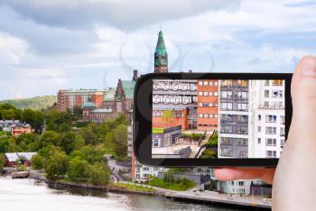 travel concept - tourist taking photo of municipal houses and hospital in Stockholm, Sweden on mobile gadget