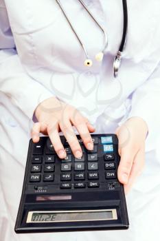 doctor calculates the cost of treatment on calculator