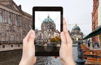 travel concept - tourist takes photo of Spree river and Berliner Dom in Berlin, Germany on tablet pc