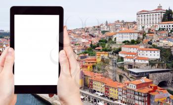 travel concept - tourist photograph historical center of Porto city, Portugal on tablet pc with cut out screen with blank place for advertising logo