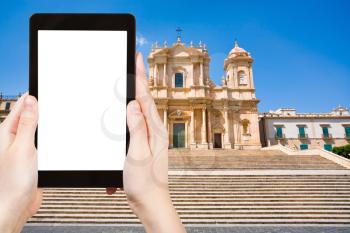 travel concept - tourist photograph the Cathedral in late Baroque style town Noto, Sicily, Italy on tablet pc with cut out screen with blank place for advertising logo