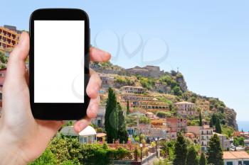travel concept - tourist photograph Taormina resort city from Castelmola town, Sicily, Italy on tablet pc with cut out screen with blank place for advertising logo